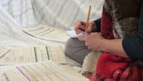 Studying-on-the-Couch-with-a-blanket-over-the-legs-with-Scattered-Papers-and-Notebooks