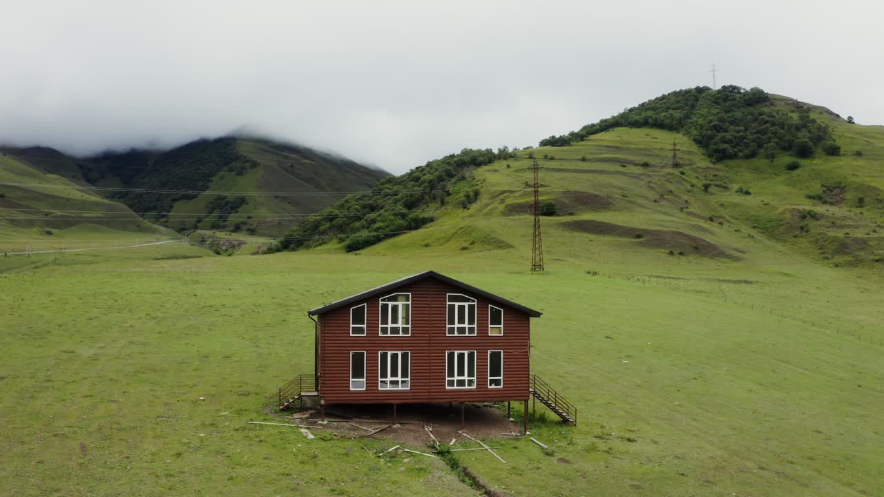 cabaña de madera roja en un valle de montaña