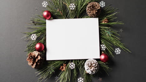 video of christmas decorations and white card with copy space on black background