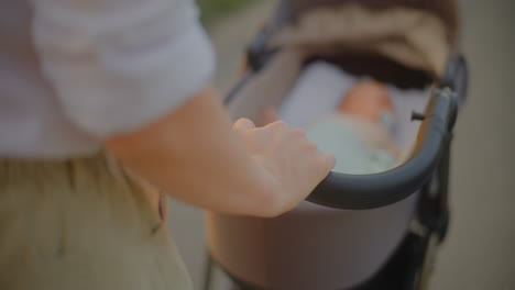 woman playing with baby in stroller at sunset