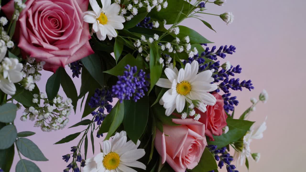 Angolazione ravvicinata di una vivace composizione floreale con rose, margherite e lavanda