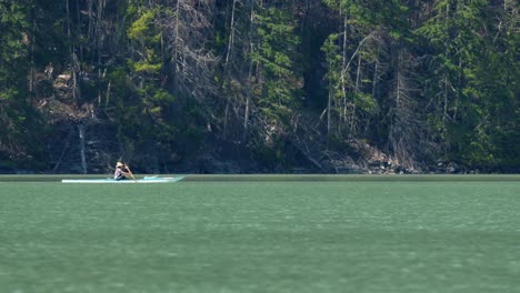 person rowing boat in the lillooet lake, bc, canada