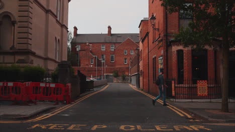 slow motion hand held still shot of a man walking across a road