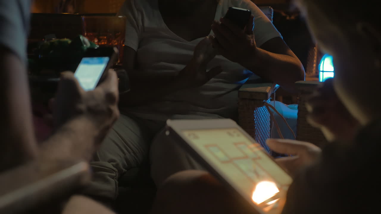 niño y adultos ocupados con electrónica en el café