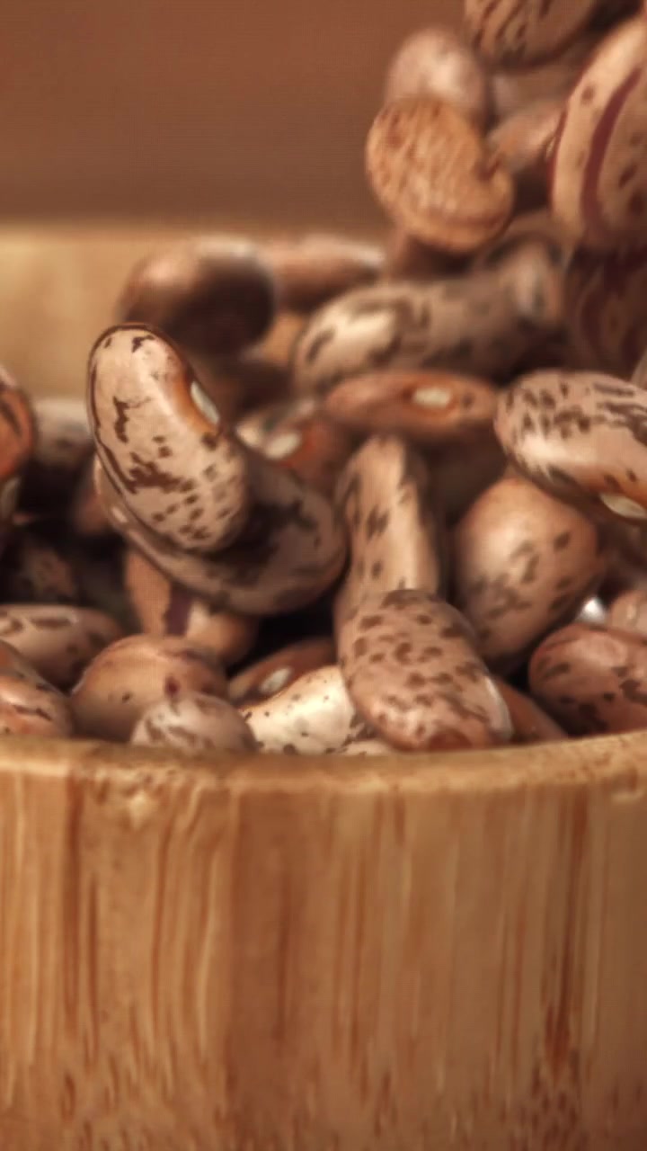 Slow Motion of Pinto Beans Pouring into a Wooden Bowl