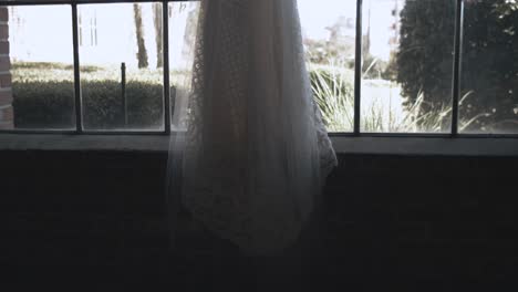 dolly right shot showing beautiful wedding bridal gown in window ready for marriage