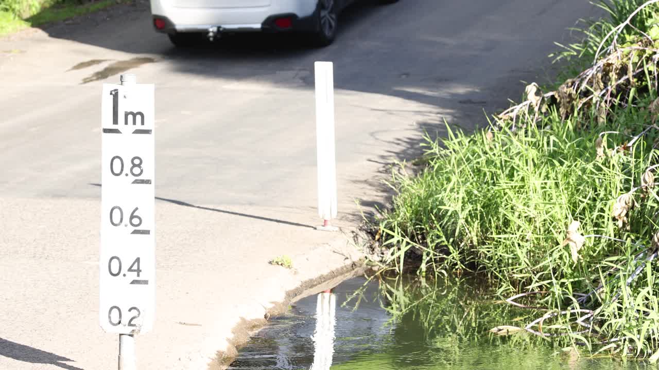 A car drives over a shallow stream