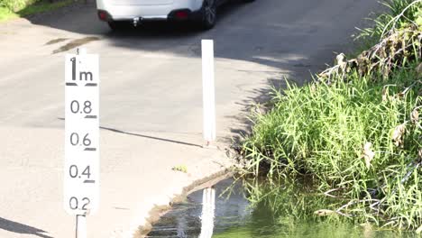 a car drives over a shallow stream