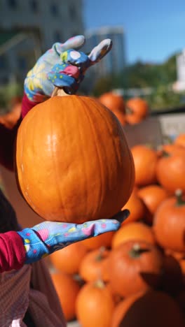 mujer sosteniendo una gran calabaza