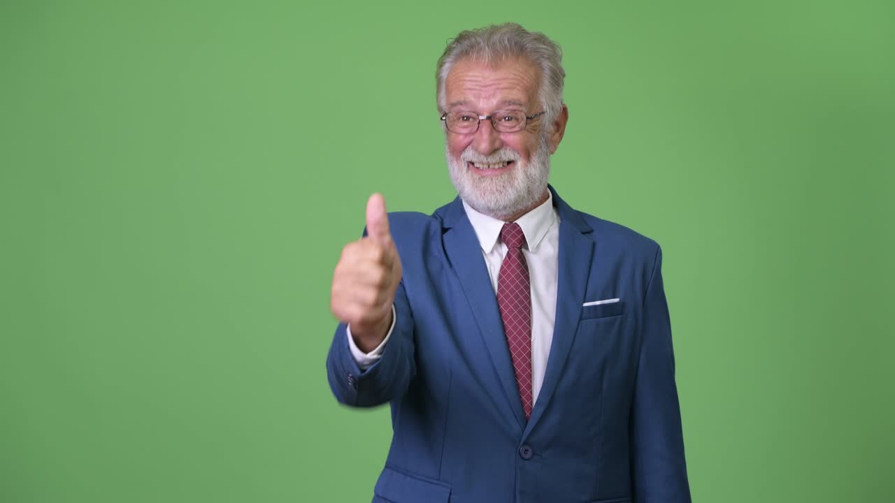 hombre de negocios barbudo y guapo contra un fondo verde.