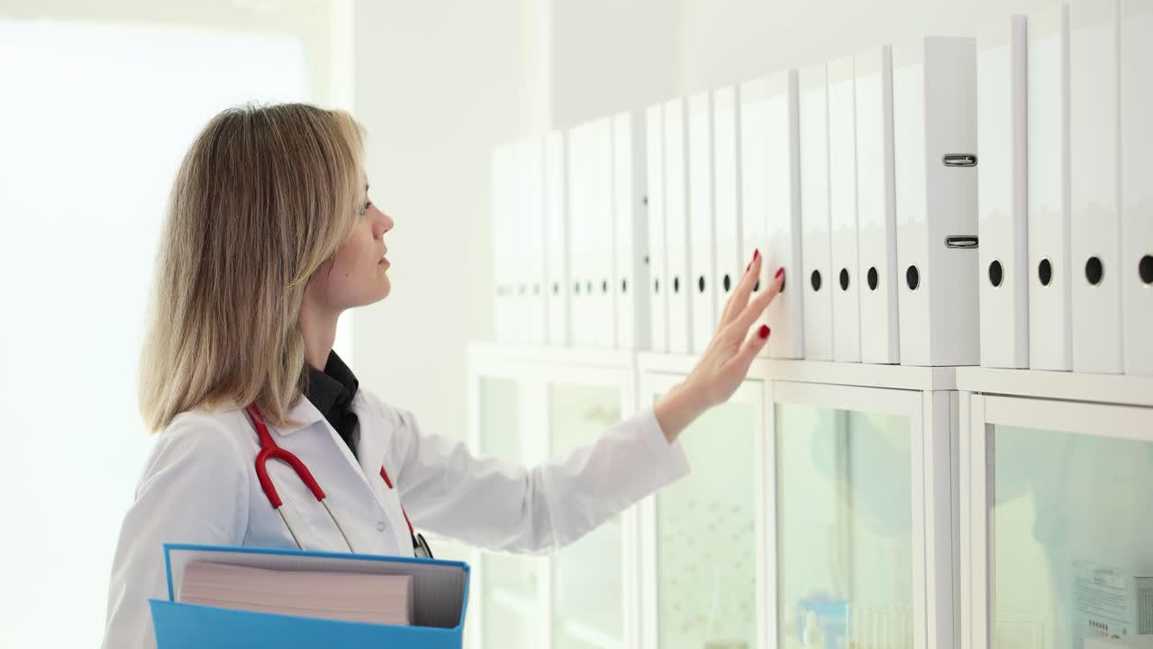 Dottoressa che cerca cartelle cliniche dei pazienti in clinica