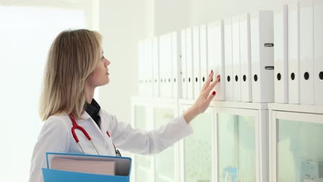 female doctor searching for patient files in clinic
