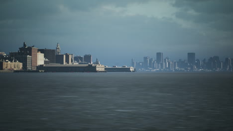 city skyline viewed from the waterfront under a cloudy sky in late afternoon