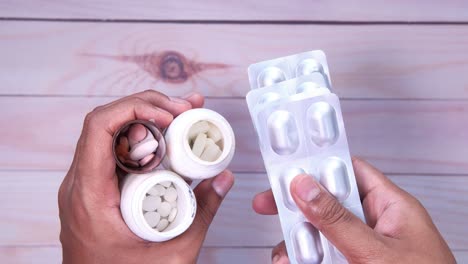 manos sosteniendo frascos de medicamentos y paquetes de ampollas