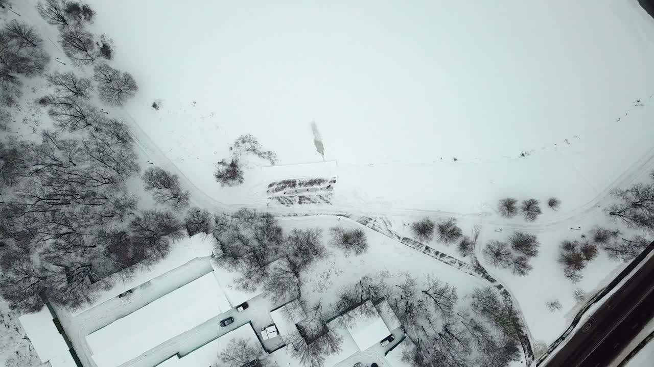 벤치, 빈티지 랜턴 및 트랙 및 발자국과 함께 눈으로 인 보행로와 함께 겨울 공원에서 호수 연안의 공중 상단 뷰