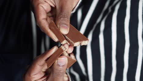 persona que come una barra de chocolate