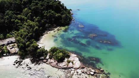 aerial orbiting shot showing brazilian paradise island with private sandy beach, blue ocean shore and forest trees in summer