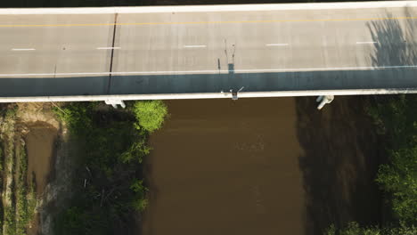 Wolf-river-bridge-in-collierville,-tn,-with-lush-greenery-in-bright-daylight,-casting-shadows,-aerial-view