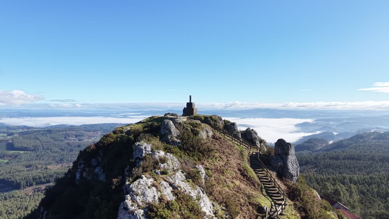 4K Drone shot of Pico Sacro peak near Santiago de Compostela. Panoramic views of the Ulla River valley, green Galician landscape, and the legendary "Calle de la Reina" rock formation under a clear sky