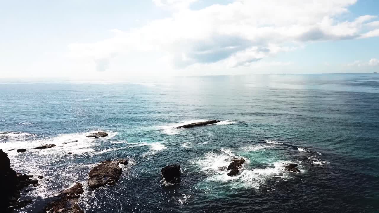 Aerial top view of large waves. Drone shot of rocky seashore. Sea coastline with extreme waves hitting rocks. Waves crashing rocky beach. Sea waves splashing