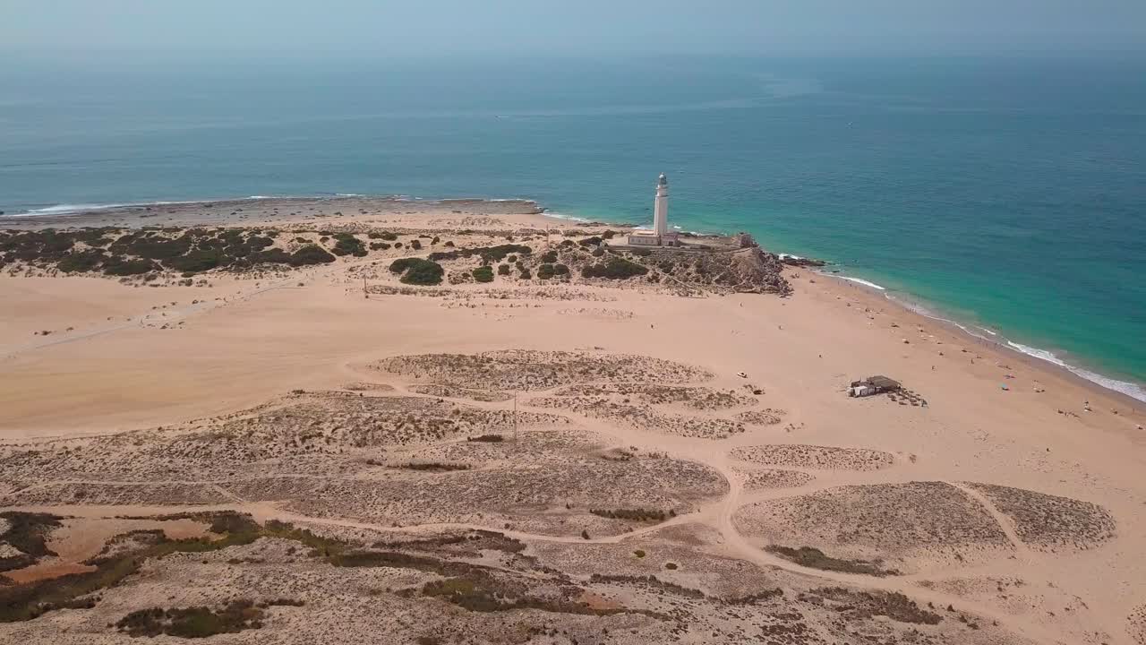 playa de cabo trafalgar y faro con aguas tranquilas del paisaje marino durante el verano en cádiz, españa