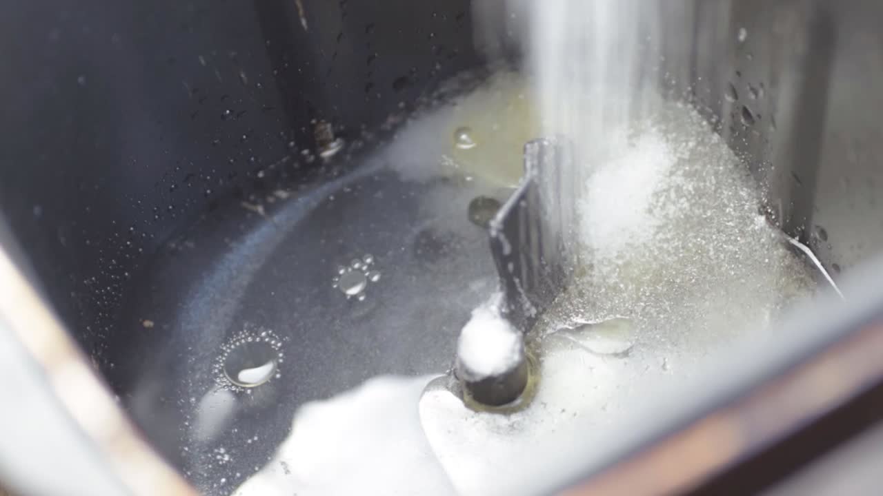 Pouring flour into a bread machine close up shot