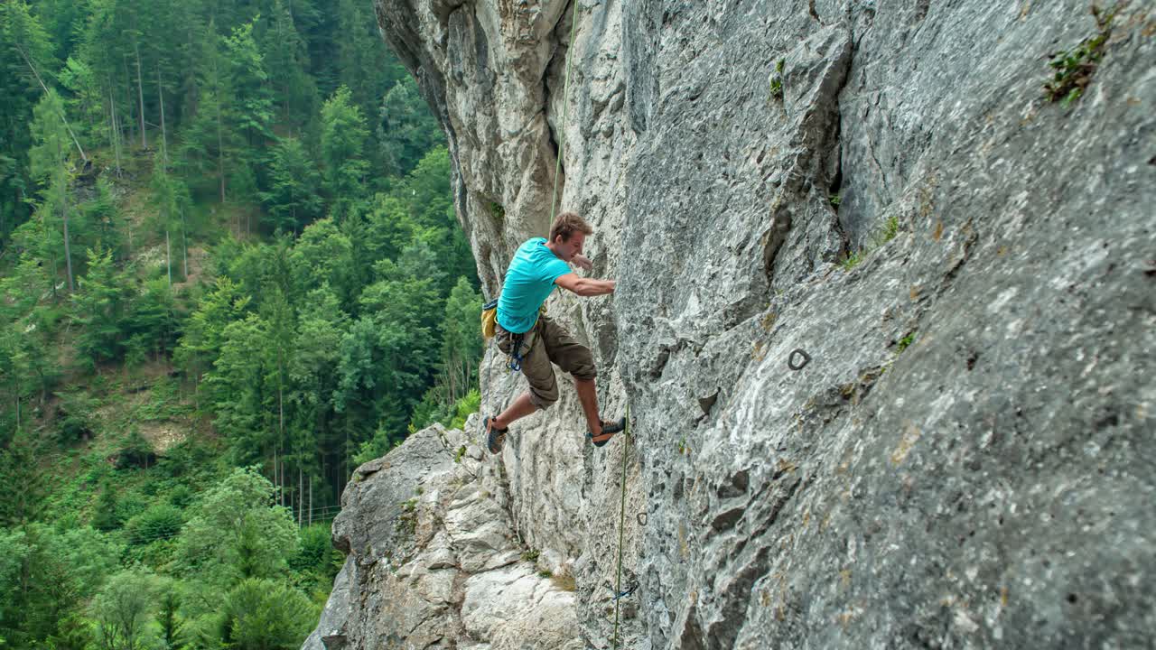 Caucasian adult man climbing rocky mountain Burjakove Peci, Slovenia