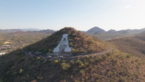 aerial view of a mountain in desert landscape with winding road