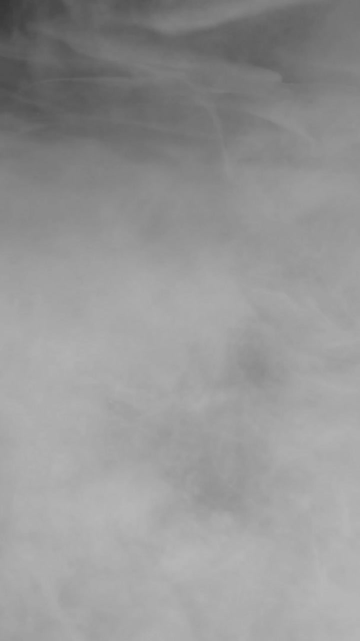 A dense, bright white fog or smoke texture fills the vertical frame. Ideal for creating a "whiteout" effect, transitions, or clean atmospheric scenes