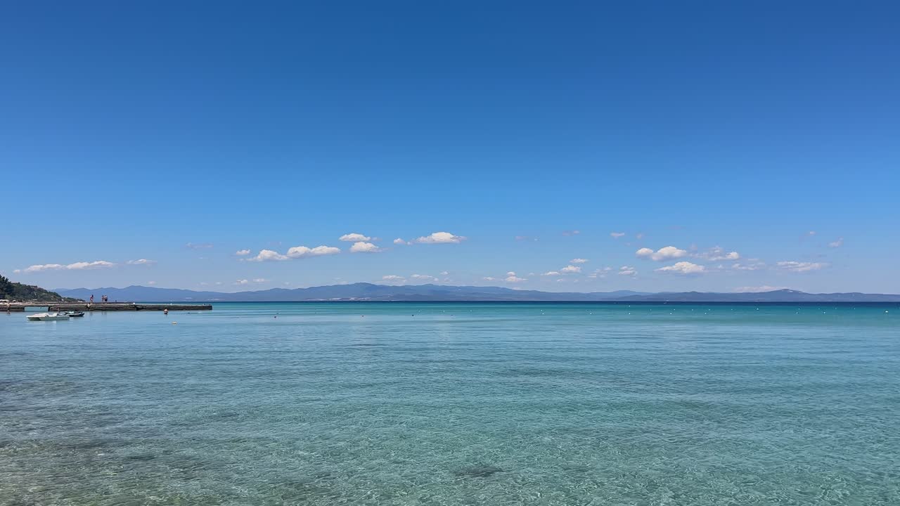Stunning beach scene in Halkidiki, Greece, with elegant sunbeds facing the crystal-clear turquoise sea. A perfect summer escape in the heart of the Aegean.