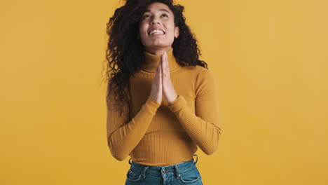 una mujer afroamericana feliz sobre un fondo naranja.