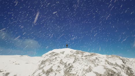 una persona de pie en la cima de una montaña cubierta de nieve. frío paisaje nevado vista aérea, irreal 4k una captura de pantalla