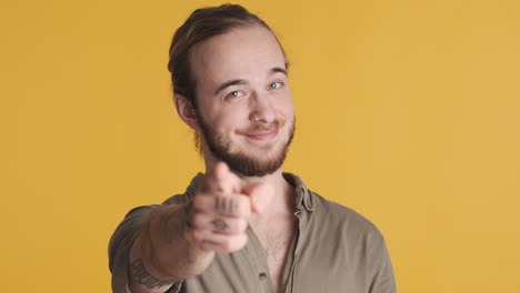 caucasian young man pointing index finger in camera.