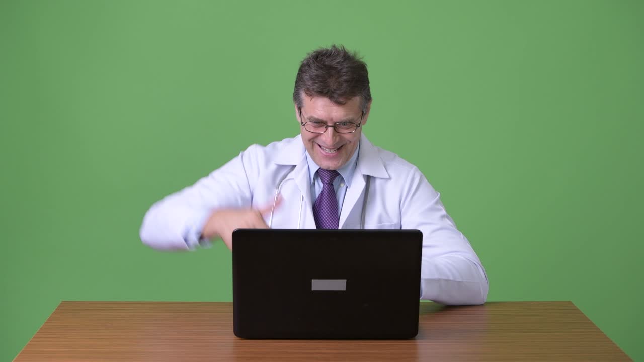 hombre maduro y guapo médico contra fondo verde