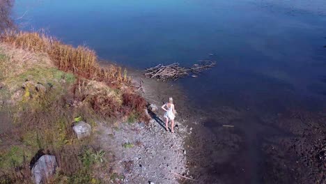 aerial of young women looking in a field towards a lake