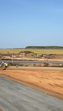 road construction site with worker and heavy equipment