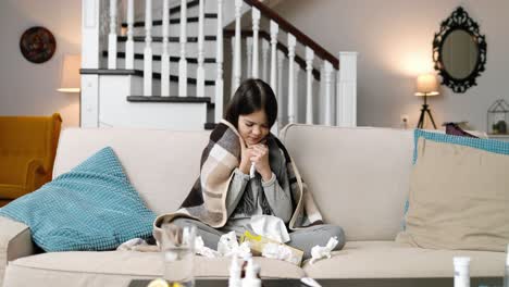 niña enferma sentada en casa, estornudando y tosiendo