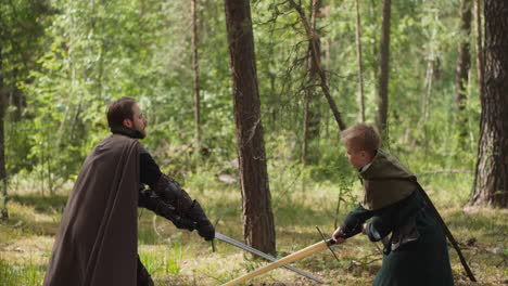 knight-teaches-boy-to-fight-with-sword,-ammunition