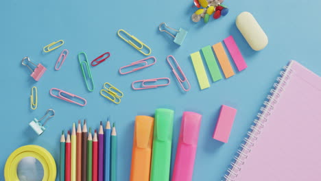 video de varios suministros de oficina, bolígrafos, clips de papel, alfileres sobre fondo azul