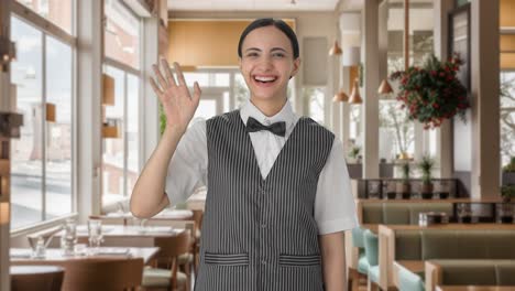 happy indian woman waiter saying hi and waving