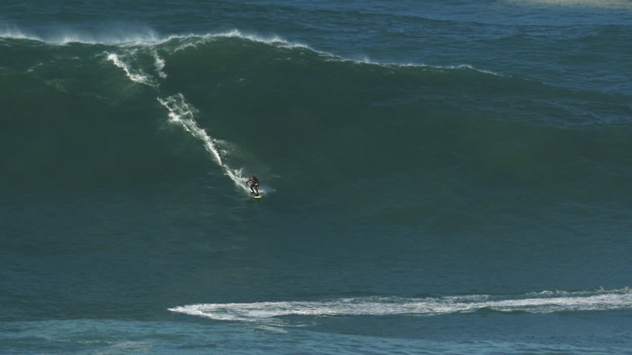 포르투갈 나자레에서 괴물 파도를 타고 있는 큰 파도 서퍼 카이오의 슬로우 모션