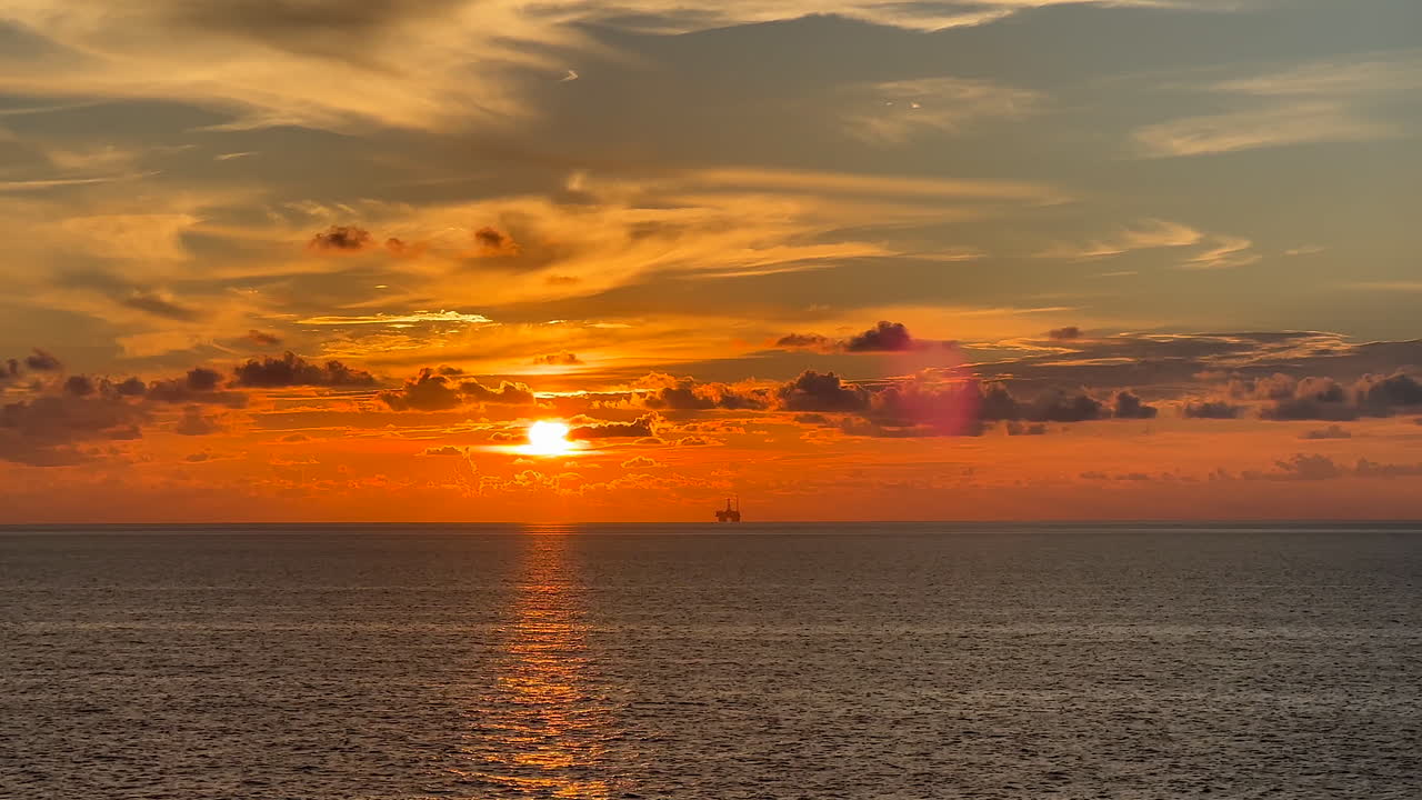 piattaforma petrolifera nel golfo del messico al tramonto con cielo arancione e blu