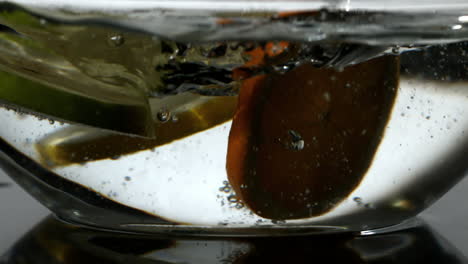 fruit slices falling into bowl of water