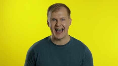 Portrait-of-young-caucasian-man-posing-in-green-t-shirt.-Amazed-handsome-guy-shocked,-surprised