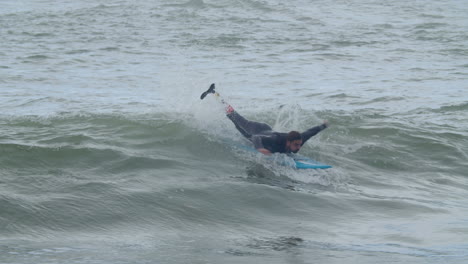 Sportive-Man-In-Wetsuit-With-Artificial-Leg-Surfing-In-The-Ocean