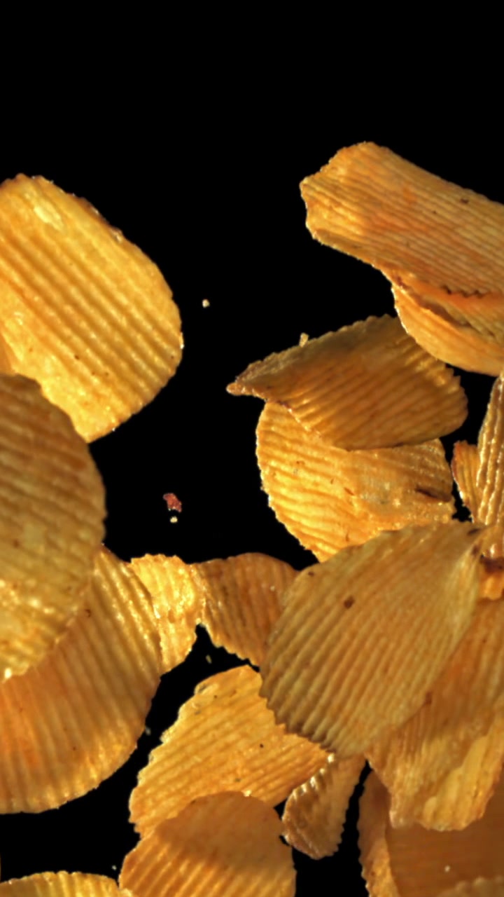 Golden Ruffled Potato Chips Falling and Floating in Slow Motion