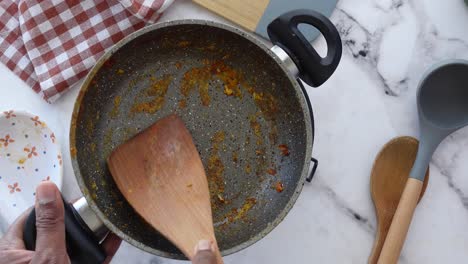 a person cleaning a pan after cooking