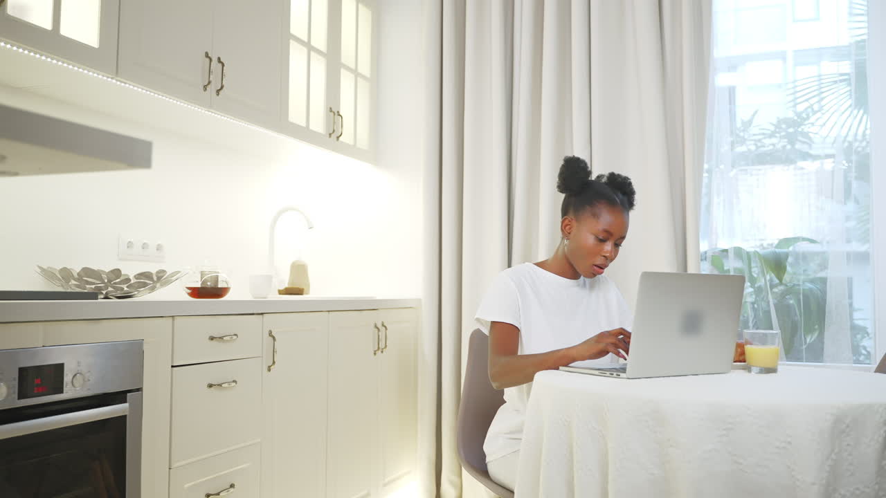 Woman working on laptop in a modern kitchen