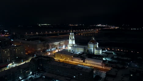 vista aérea nocturna de una ciudad con una iglesia y un río en invierno