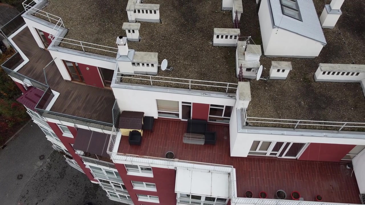 Luftfoto af en drone, der flyver over boligbygninger, med optagelser af tage og arkitektur.